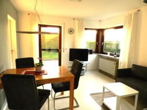a living room with a dining room table and a kitchen at Ferienwohnung Schwendemann in Laichingen