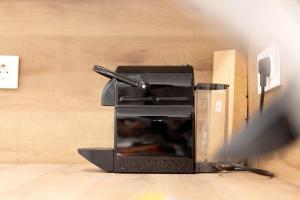 a black espresso machine sitting on the floor at Appartment Antilope im Würmtal in Gräfelfing