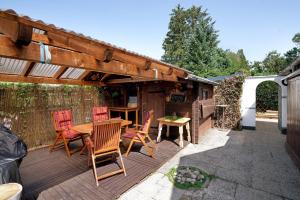 a patio with a wooden table and chairs on a deck at Appartment Antilope im Würmtal in Gräfelfing