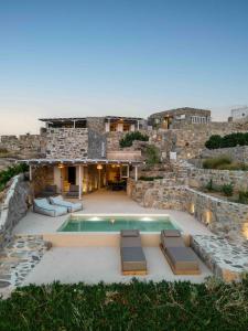 a house with a swimming pool in front of a stone building at Villa Vagia in Vayiá