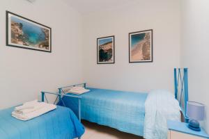two beds in a room with three pictures on the wall at Dimora di Artemide in Otranto