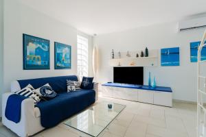 a living room with a blue couch and a tv at Dimora di Artemide in Otranto