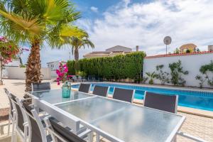 a table and chairs in front of a swimming pool at Modern villa with great location in Ciudad Quesada
