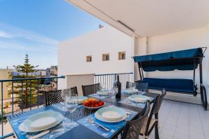 a dining table with a bowl of fruit on a balcony at Dimora di Artemide in Otranto