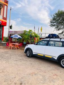 a white car parked in front of a table at Ligree Hotel and Restaurant in Jatwāra +6 photos