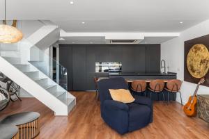 a living room with a staircase and a blue chair at Dúplex Paradise above the sea in Benalmádena