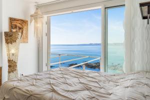 a bedroom with a bed and a large window at Dúplex Paradise above the sea in Benalmádena +18 photos