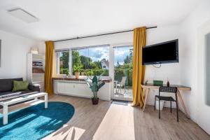 a living room with a large window and a tv at Ferienwohnung Deister Blick in Rodenberg