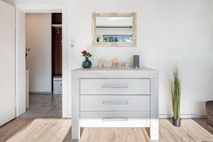 a white dresser in a living room with a mirror at Ferienwohnung Deister Blick in Rodenberg +18 photos