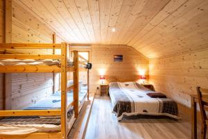 two bunk beds in a cabin with wooden walls at Les Chalets de la Revue in Flumet