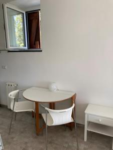 a table and chairs in a room with a window at Fattorialmare Rossa in Camogli