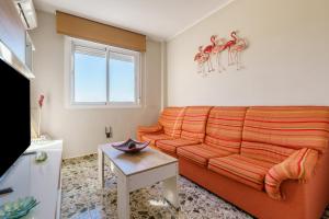 a living room with a orange couch and a table at Apartamento Carmen in Fuengirola