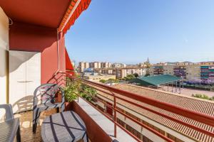 a balcony with a chair and a view of a city at Apartamento Carmen in Fuengirola