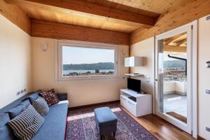 a living room with a couch and a large window at Appartamento Rocchetta in Salò