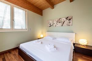a bedroom with a large white bed with towels on it at Appartamento Rocchetta in Salò