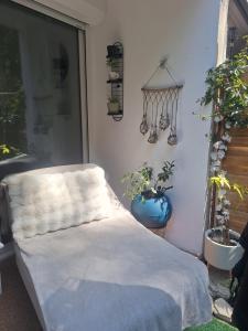 a bed in a room with plants and a window at petit cocon in Toulon