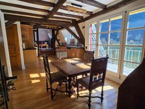 a dining room with a table and chairs and windows at Traum-Fewo Mosel-Panoramablick in Traben-Trarbach