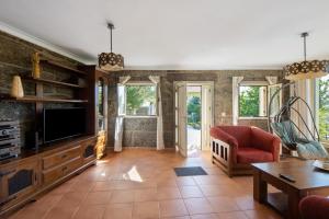 a living room with a tv and a couch at Casa do Valado in Resende
