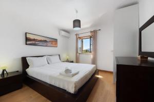 a bedroom with a white bed and a television at Casa do Valado in Resende +29 photos