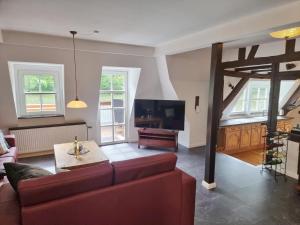 a living room with a red couch and a tv at Traum-Fewo Mosel-Panoramablick in Traben-Trarbach