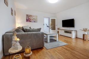 a living room with a couch and a television at Ferienwohnung Berti in Heeßen