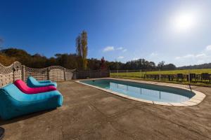 a swimming pool with a slide next to a fence at L'Ecurie in Guizengeard