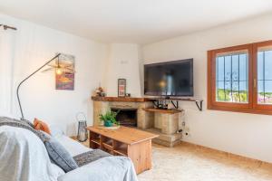 a living room with a fireplace and a flat screen tv at La Boniquesa in Benissa