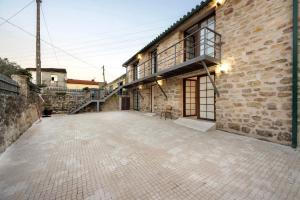 a brick building with a patio in front of it at Df Alojamentos e Suites in Coimbra