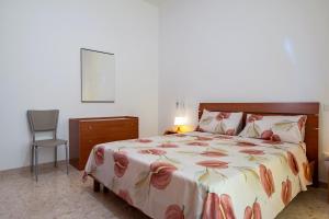 a bedroom with a large bed and a chair at Rosa dei Venti Grottaglie in Grottaglie