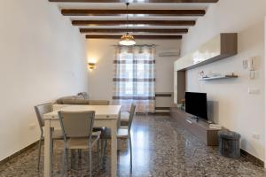 a dining room with a table and chairs and a television at Rosa dei Venti Grottaglie in Grottaglie