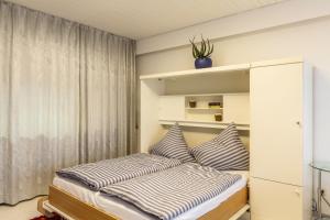 a bedroom with a bed with striped pillows at Ferienwohnung Nina in Schönwald +22 photos