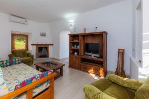 a living room with a couch and a tv at Sa Casona in Portocolom