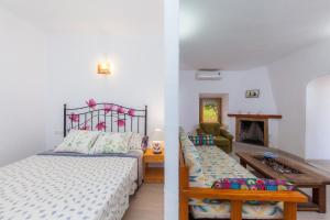 a bedroom with a bed and a living room with a fireplace at Sa Casona in Portocolom
