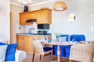 a kitchen with wooden cabinets and a table with chairs at Seeblicksuiten - Suite Seelixir in Enderndorf
