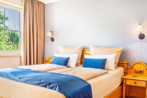 a bedroom with two beds with blue and white pillows at Seeblicksuiten - Suite Seelixir in Enderndorf