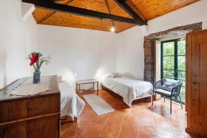 a bedroom with two beds and a table at Quinta das Queimadas in Nordeste