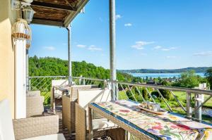 a balcony with a table and chairs and a view of the water at Seeblicksuiten - Suite Seelixir in Enderndorf