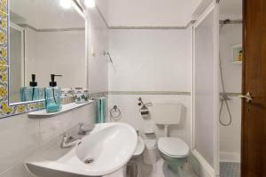 a bathroom with a sink and a toilet and a mirror at Apartamento Caravela in Armação de Pêra +16 photos