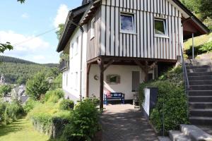 a small house with a porch and stairs to it at Ferienwohnung Voege am Waldrand in Schmallenberg +15 photos