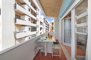 a balcony with a table and chairs on a building at Apartamento Caravela in Armação de Pêra