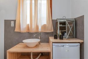 a bathroom with a sink and a bowl on a counter at En Tino 1 in Tinos