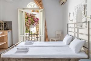 a bedroom with two beds and a balcony at En Tino 1 in Tinos +15 photos