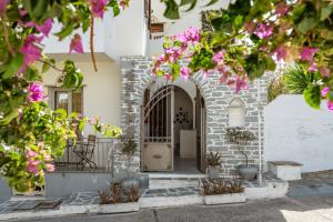 an entrance to a white building with pink flowers at En Tino 1 in Tinos