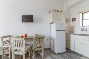 a kitchen with a small table and a refrigerator at Perasma Studio 3 in Kipri
