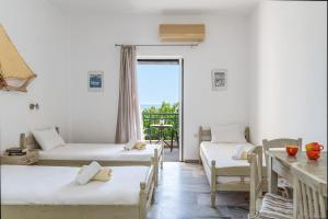 a room with two beds and a table and a window at Perasma Studio 3 in Kipri