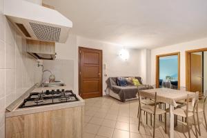 a kitchen with a stove top oven next to a table at Casa chicken - mare, monti e bikers in Finale Ligure