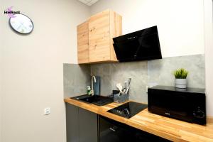 a kitchen with a counter with a sink and a microwave at MMRent Grape Room in Gdańsk
