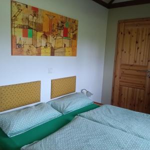 a bedroom with two beds and a painting on the wall at Bienenhaus in Dornhan