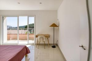 a bedroom with a desk and a table with a lamp at Villa de Luxe à Begur Vue Mer in Begur +37 photos