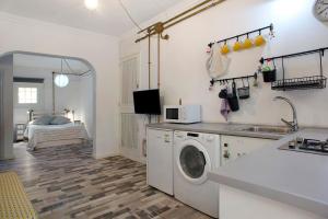 a kitchen with a sink and a washing machine in a room at Las Sales Estudio in Moya